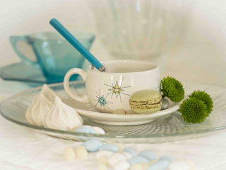 white meringue cookie with green macaron with mid-century atomic teacup, biscuit meringu&eacute; blanc avec macaron vert avec tasse &agrave; th&eacute; atomique du milieu du si&egrave;cle