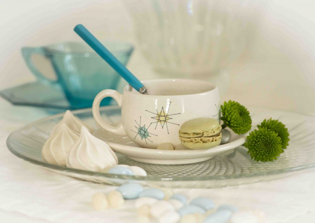 white meringue cookie with green macaron with mid-century atomic teacup, biscuit meringué blanc avec macaron vert avec tasse à thé atomique du milieu du siècle