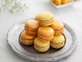 yellow and orange macarons on pewter plate, macarons jaunes et orange sur assiette en &eacute;tain