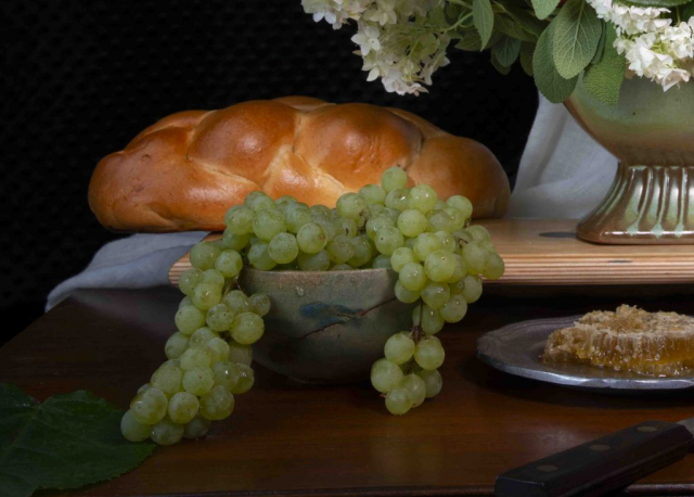 Golden braided bread with green grapes and natual honey
